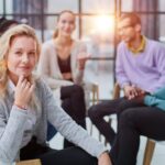 smiling_businesswoman_looking_at_camera_at_seminar_with_her