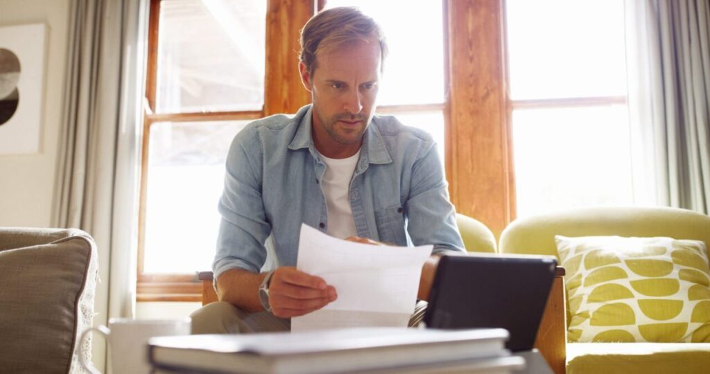 Personne comparant des offres de crédit sans justificatif avec une calculatrice et un carnet de budget sur une table
